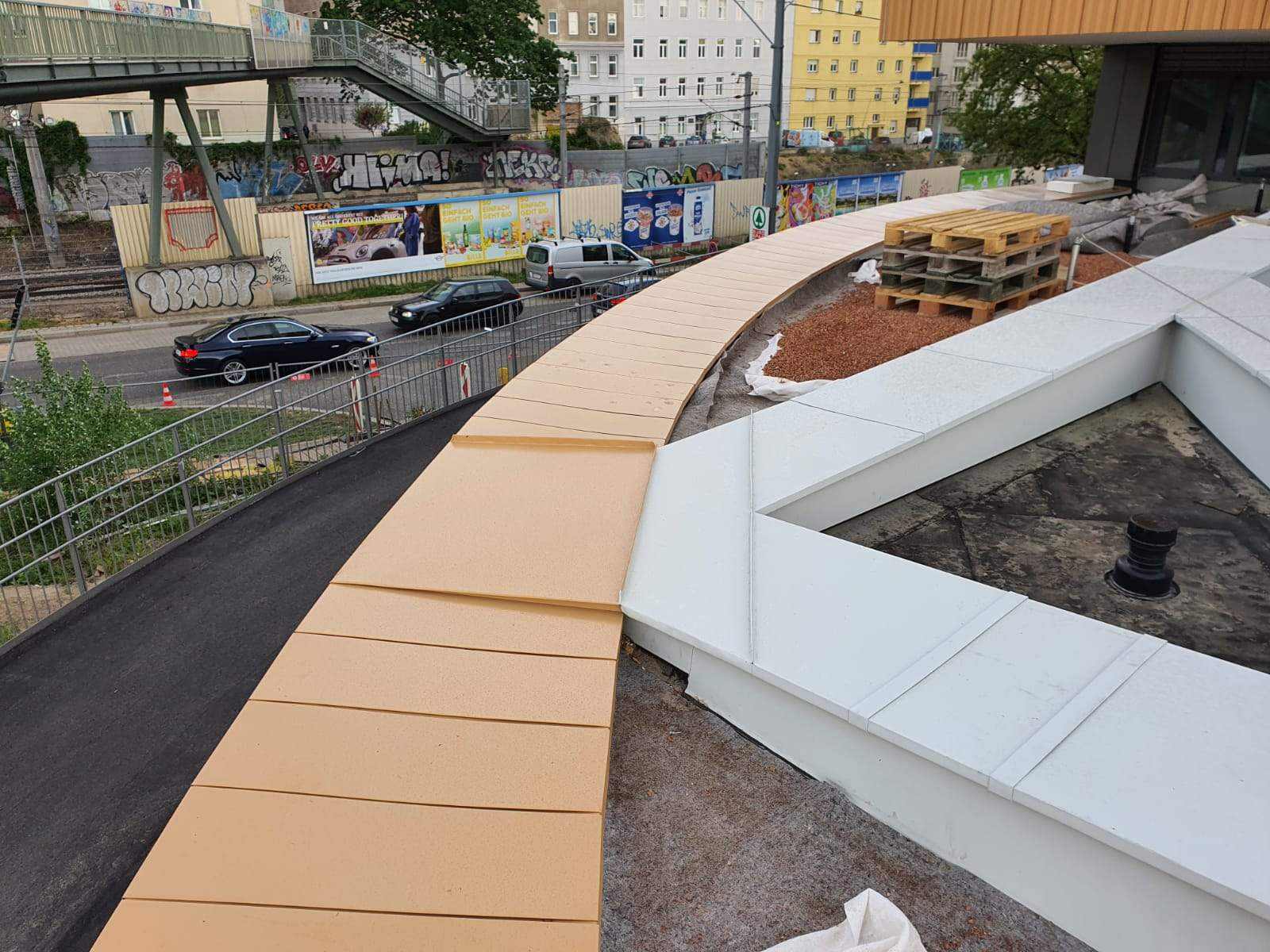 Geschwungene Attikaabdeckung aus Blech oberhalb einer Straße