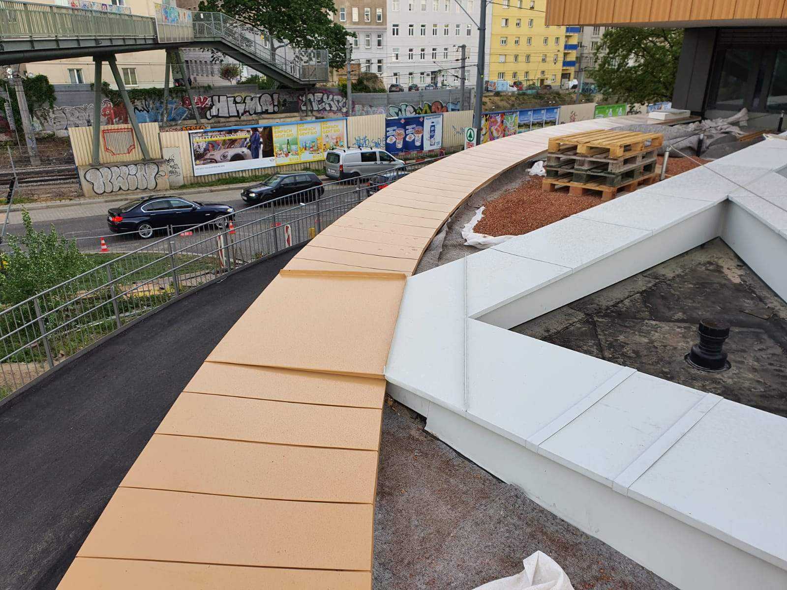Geschwungene Attikaabdeckung aus Blech oberhalb einer Straße