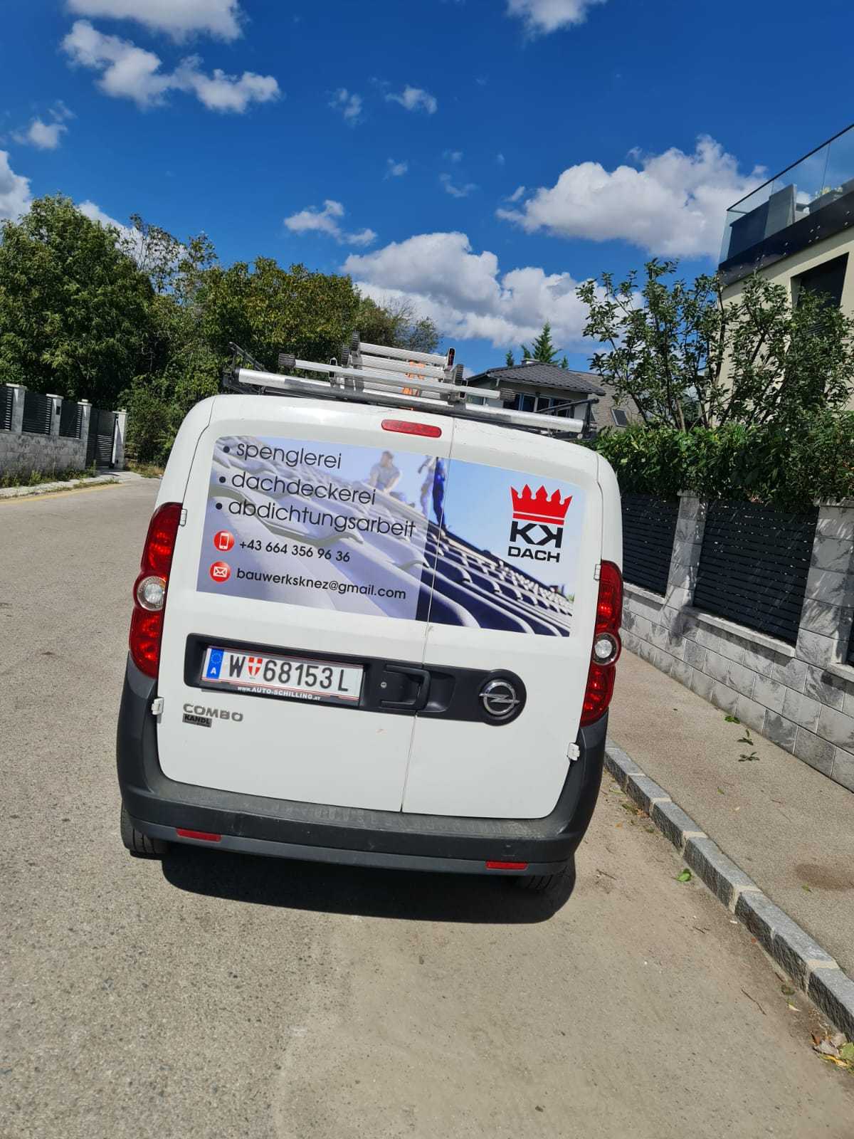 Firmenwagen von KK Dach von hinten mit Logo und Beschriftung