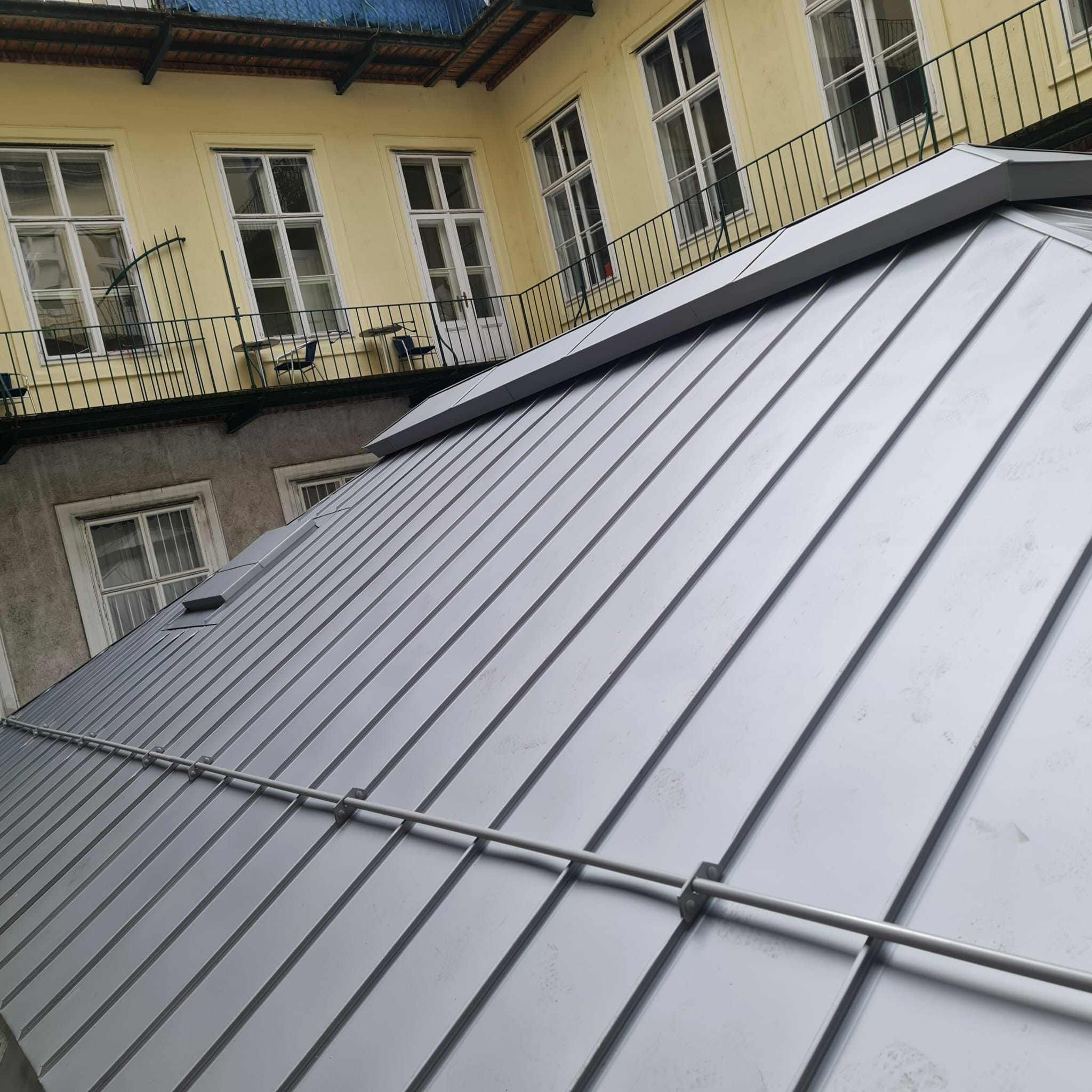 Stehfalzdach aus Metall mit Gaube, Blick auf die Fassaden im Innenhof